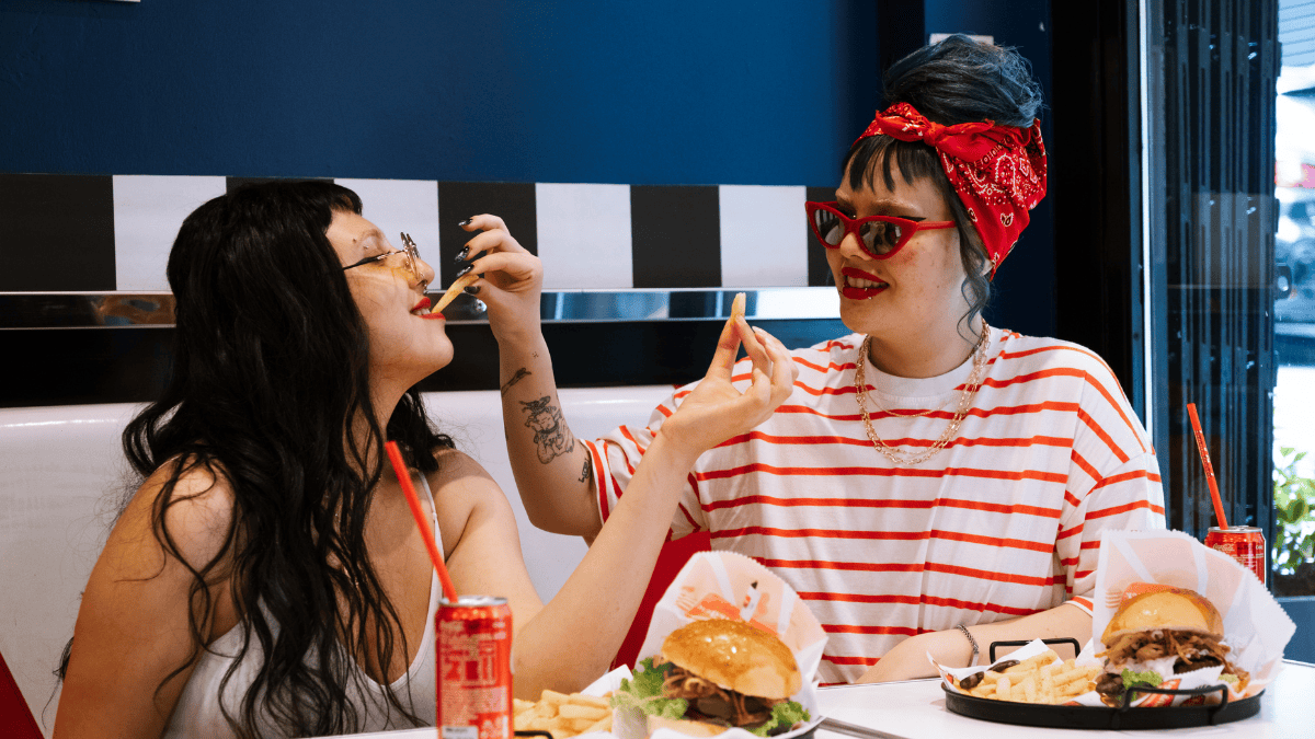 Lesbian couple enjoying a playful conversation over dinner on a first date